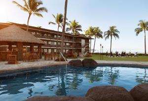 科洛阿Koa Kea Resort on Poipu Beach的一个带大型游泳池和棕榈树的度假村