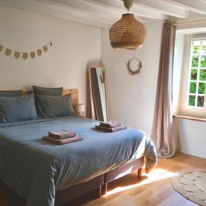 HermerayLe Clos des Noues的一间卧室配有一张床,上面有两条毛巾