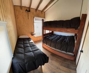 阿劳科Cabaña Pilpilen - Curaquilla Lodge "Entre humedales y el Mar"的客房设有两张双层床和睡袋