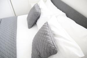 伦敦Twelve Thirty Serviced Apartments - Balham的白色枕头上带灰色领带的床