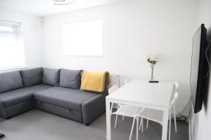 伦敦Twelve Thirty Serviced Apartments - Balham的客厅配有沙发和桌子