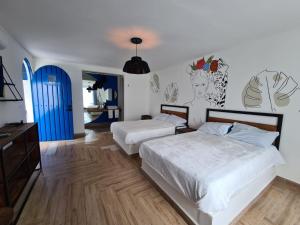 迪坡斯特兰CASA NDOMI TEPOZ的一间卧室设有两张床和一扇蓝色的门