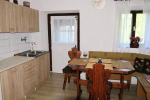 Brod na KupiKuća za odmor Beljan的厨房配有桌椅和水槽。