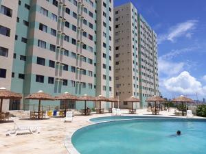 马塞约Apartamento com 2 quartos de FRENTE PARA O MAR的一座位于酒店前方的游泳池,酒店前方有高楼