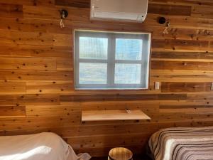 益城町Glamping Village Leaf - Vacation STAY 65726v的一间卧室设有木墙和窗户
