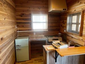 益城町Glamping Village Leaf - Vacation STAY 65726v的厨房设有木墙、炉灶和冰箱。