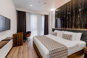库塔伊西Kutaisi Inn的配有一张床和一台平面电视的酒店客房