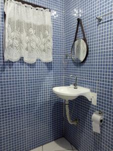圣塞巴斯蒂安Casa da Fê的蓝色瓷砖浴室设有水槽和镜子