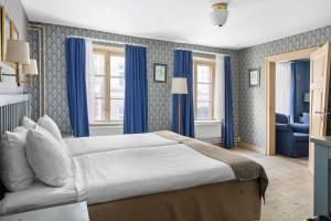 马尔默皇家贝斯特韦斯特酒店的一间卧室配有一张带蓝色窗帘的大床