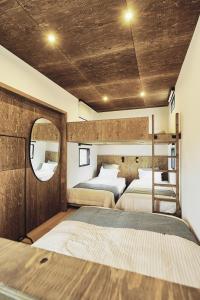 山中湖村GLANSTELLA CABIN Fujiyamanakako的一间卧室配有两张床和镜子