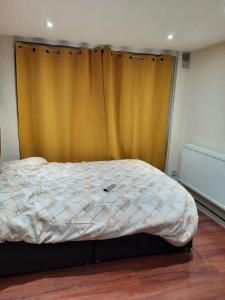 WellingRelevant properties的卧室内的一张床位,配有黄色窗帘