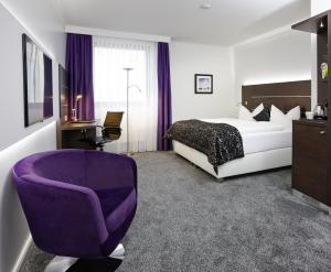 菲林根-施文宁根中心酒店的酒店客房,配有一张床和一张紫色椅子
