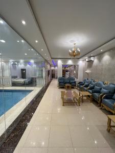 哈伊勒شاليه فاملي دي family day的酒店大堂设有游泳池和蓝色椅子