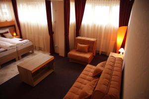 米特罗维察Hotel North City的酒店客房,配有沙发、床和椅子