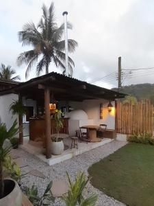 巴拉-沙希Hakuna Studios Barra do Sahy的一个带桌子和棕榈树的房子