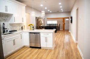坦帕Glamorous Chic & Stylish New Renovated Ybor, Dt的厨房铺有木地板,配有白色橱柜。