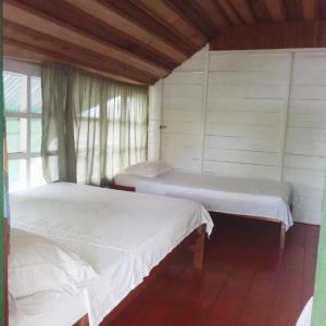 Puerto NariñoHotel Lomas del Paiyü的带窗户的客房内的两张床