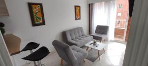 麦德林Hermoso Apartamento Ubicado en Zona Céntrica de Medellín的客厅配有椅子、沙发和桌子