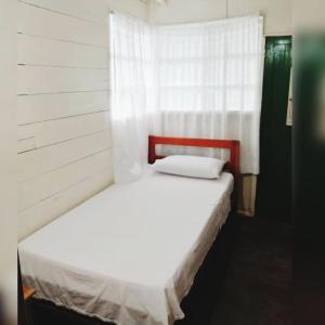 Puerto NariñoHotel Lomas del Paiyü的窗户客房内的一张白色床