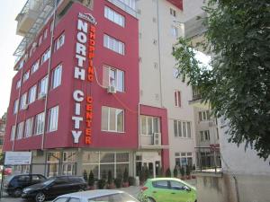 米特罗维察Hotel North City的一面有红色标志的建筑物