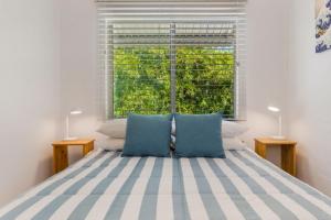 努萨角Kareela Court 4 Kareela Avenue 14的一间卧室配有一张带蓝色枕头的床和一扇窗户。