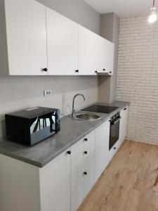 雅西Apartament incantator Iasi Copou的厨房配有白色橱柜和水槽