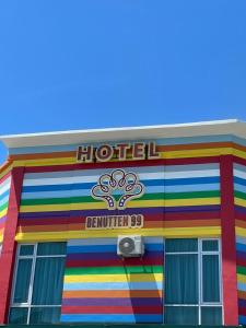 Kampong Parit TengahBENUTTEN 99 HOTEL的一座有彩虹彩虹色的建筑,带有标志的酒店