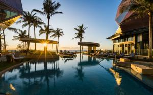 黄金海岸The Langham, Gold Coast and Jewel Residences的棕榈树和建筑的度假游泳池