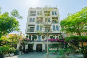 岘港Dérive Boutique Villa & Apartment Da Nang的前面有鲜花的白色建筑