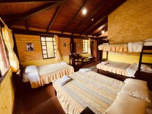 巴尼奥斯Hostería EL Trapiche Lodge & Spa的小木屋内带三张床的房间