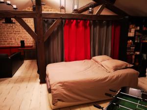 ClairvauxMaison familiale de l Abbaye的一间卧室配有一张带红色窗帘的天蓬床