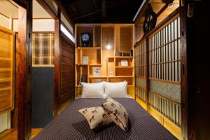 东京Bamba Hotel Tokyo-Private Townhouse-的卧室配有一张床铺,位于带木墙的房间内