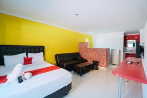 BalianRedDoorz at Kawaii Apartment Jimbaran的酒店客房,配有床和沙发
