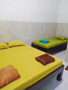 哲帕拉Homestay Premium 45的配有黄色床单的客房内的两张床
