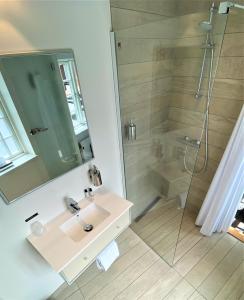 斯基沃Hotel Skivehus的一间带水槽和淋浴的浴室