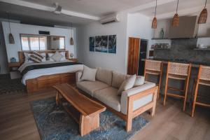 乌鲁瓦图Legends Beachfront Resort的客厅配有床和沙发