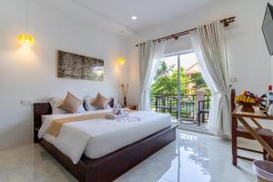 Phumĭ Ta PhŭlAngkor Rithy Residence的一间带大床的卧室和一个阳台