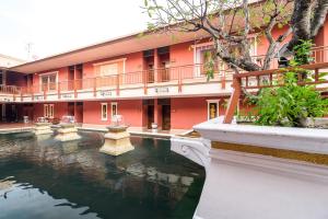 暖武里府Ruen Rattana Resort的大楼前有池塘的建筑