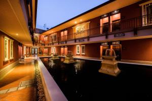 暖武里府Ruen Rattana Resort的一座建筑物中央的游泳池