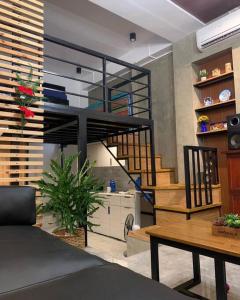 达古潘JORA LOFT- modern industrial apartment 1-A的客厅设有螺旋楼梯和桌子