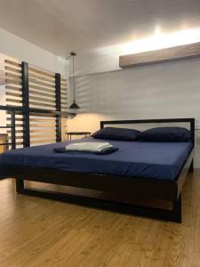 达古潘JORA LOFT- modern industrial apartment 1-A的一间卧室配有一张带蓝色床单的大床