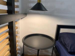 达古潘JORA LOFT- modern industrial apartment 1-A的一张黑桌,旁边是一张床和一盏灯