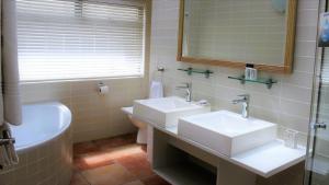 斯瓦科普蒙德Atlantic Villa Boutique Guesthouse的浴室设有2个水槽、浴缸和镜子