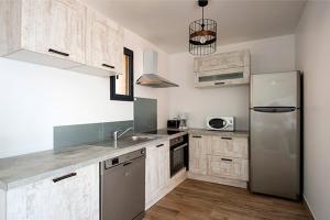 韦基奥圣露西港口Via Mare的厨房配有不锈钢冰箱和木制橱柜
