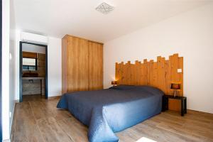 韦基奥圣露西港口Via Mare的一间卧室配有一张大床和木制床头板