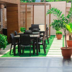 拉各斯Victoria Crown Plaza Hotel的庭院设有黑色桌椅和植物