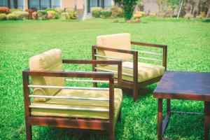 哈巴拉杜瓦Moi Koggala by DBI的草地上的两把椅子和一张桌子