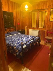泰尔米尼洛Appartamento incantevole e confortevole con Camino的木制客房内的一间卧室,配有一张床