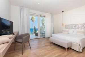 陶尔米纳Iancu Charme Apartments的白色卧室设有一张大床和电视。