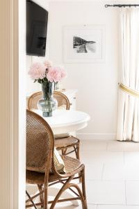 伊斯基亚Mezzatorre Hotel & Thermal Spa的餐桌、椅子和一束粉红色花瓶